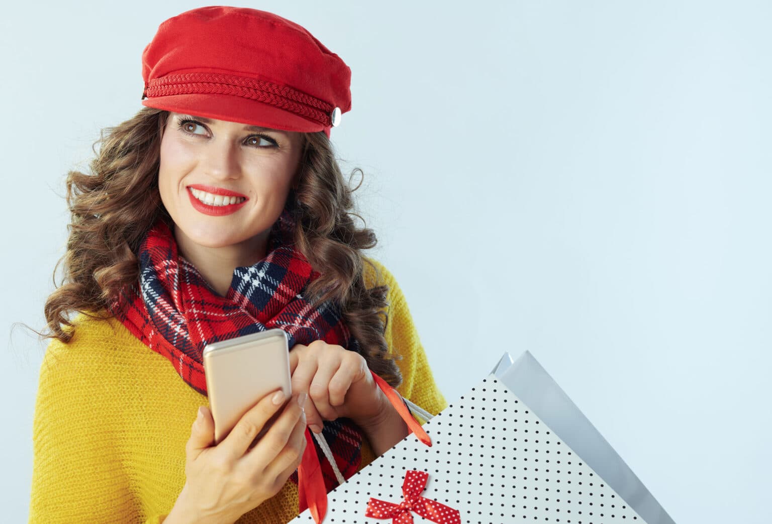 Happy shopper with phone and shopping bags